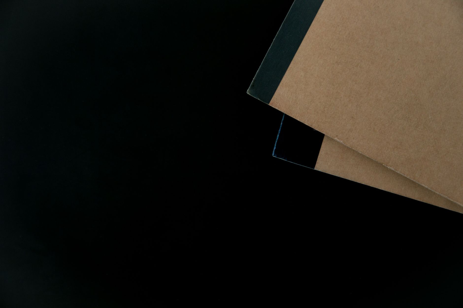 A hand writing a long list on a notepad beside a laptop