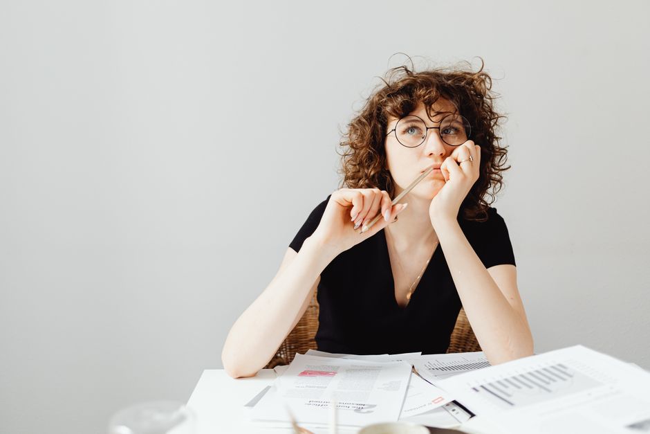 A professional reviews documents while thinking through competing options.
