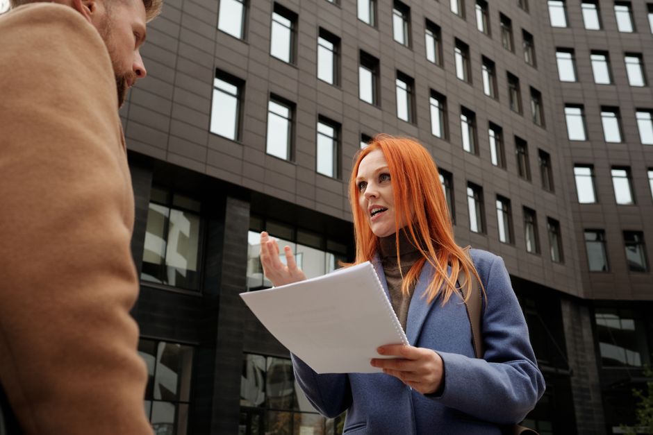 Two professionals discuss a document face to face.