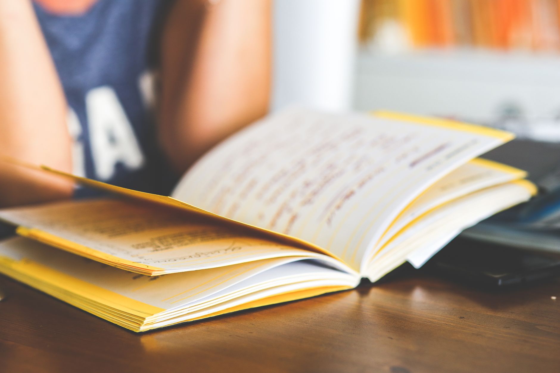 An open journal and cup of coffee on a desk, set up as part of a morning habit-tracking routine