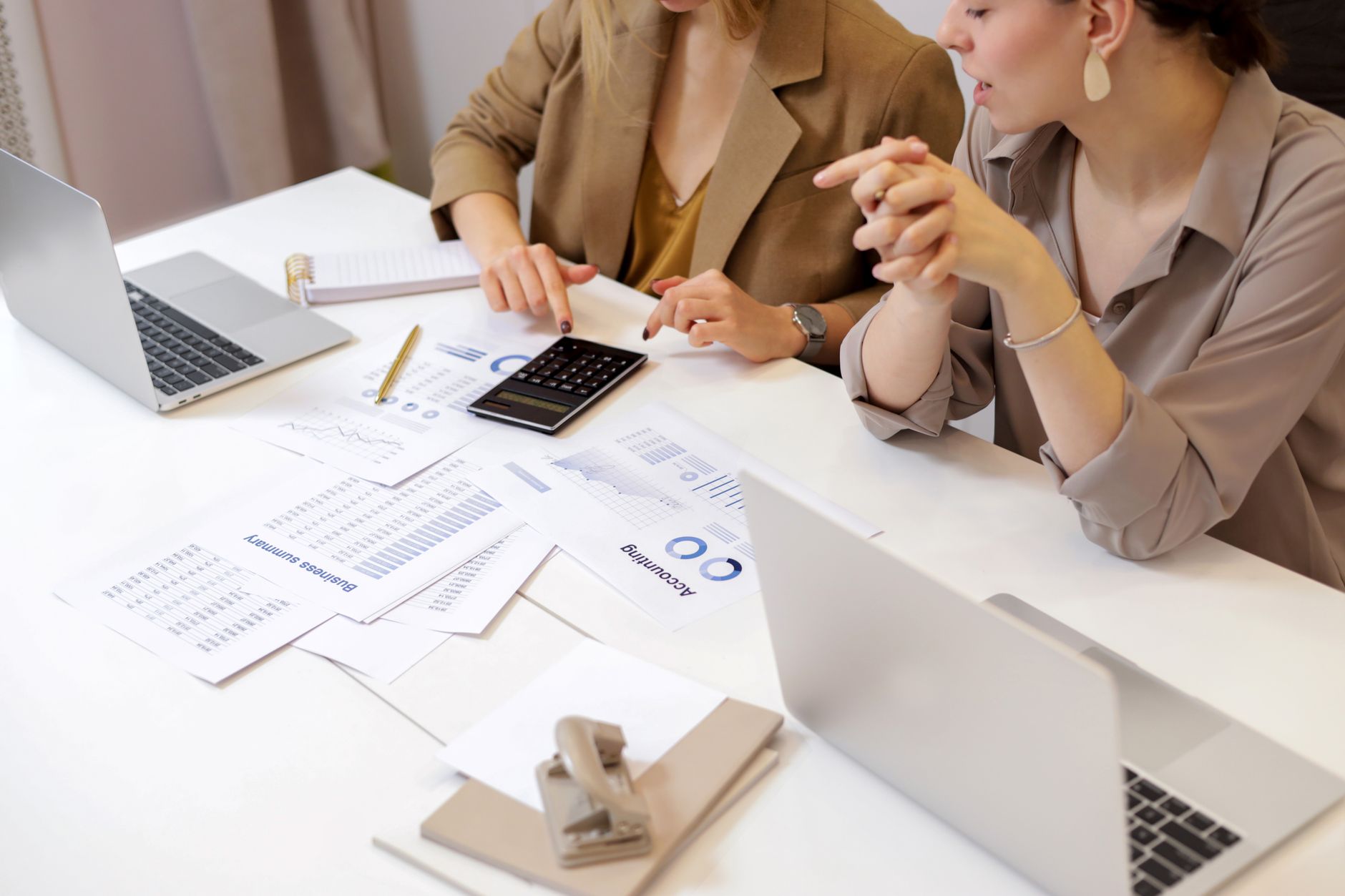 Two professionals working together over documents at a desk