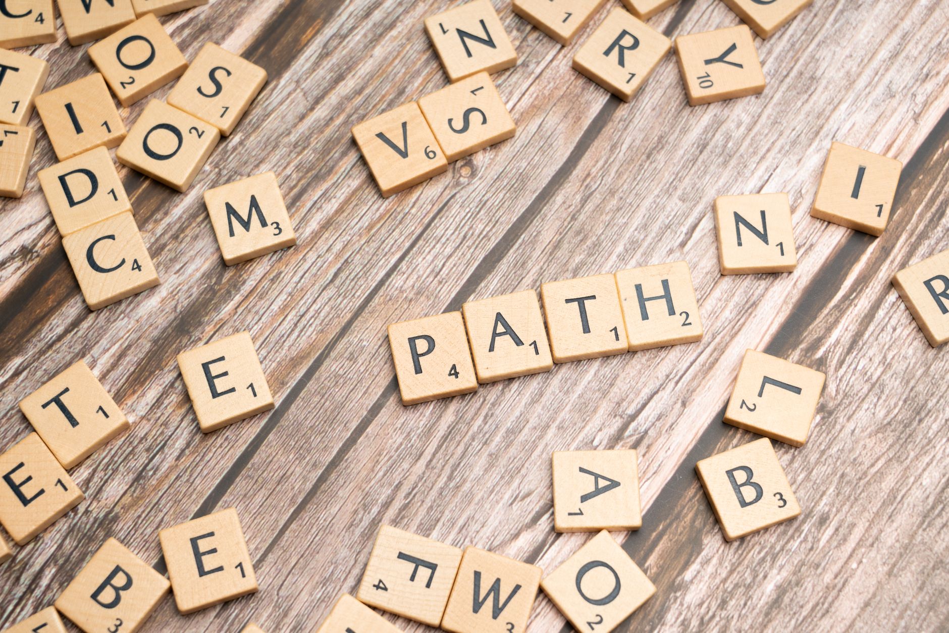 Letter tiles spelling path on a wooden surface.