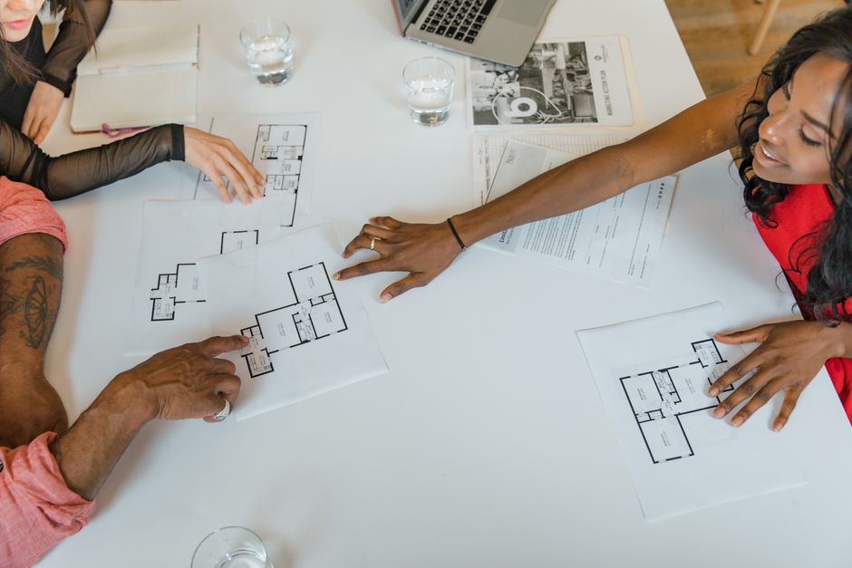 A business team examining plans together around a table.