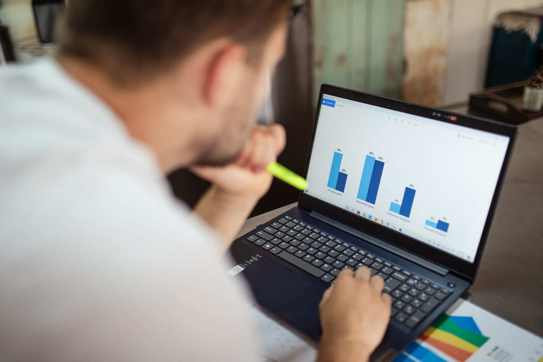 Two colleagues at a desk reviewing a printed line chart together, one of them pointing at a sharp dip in the trend
