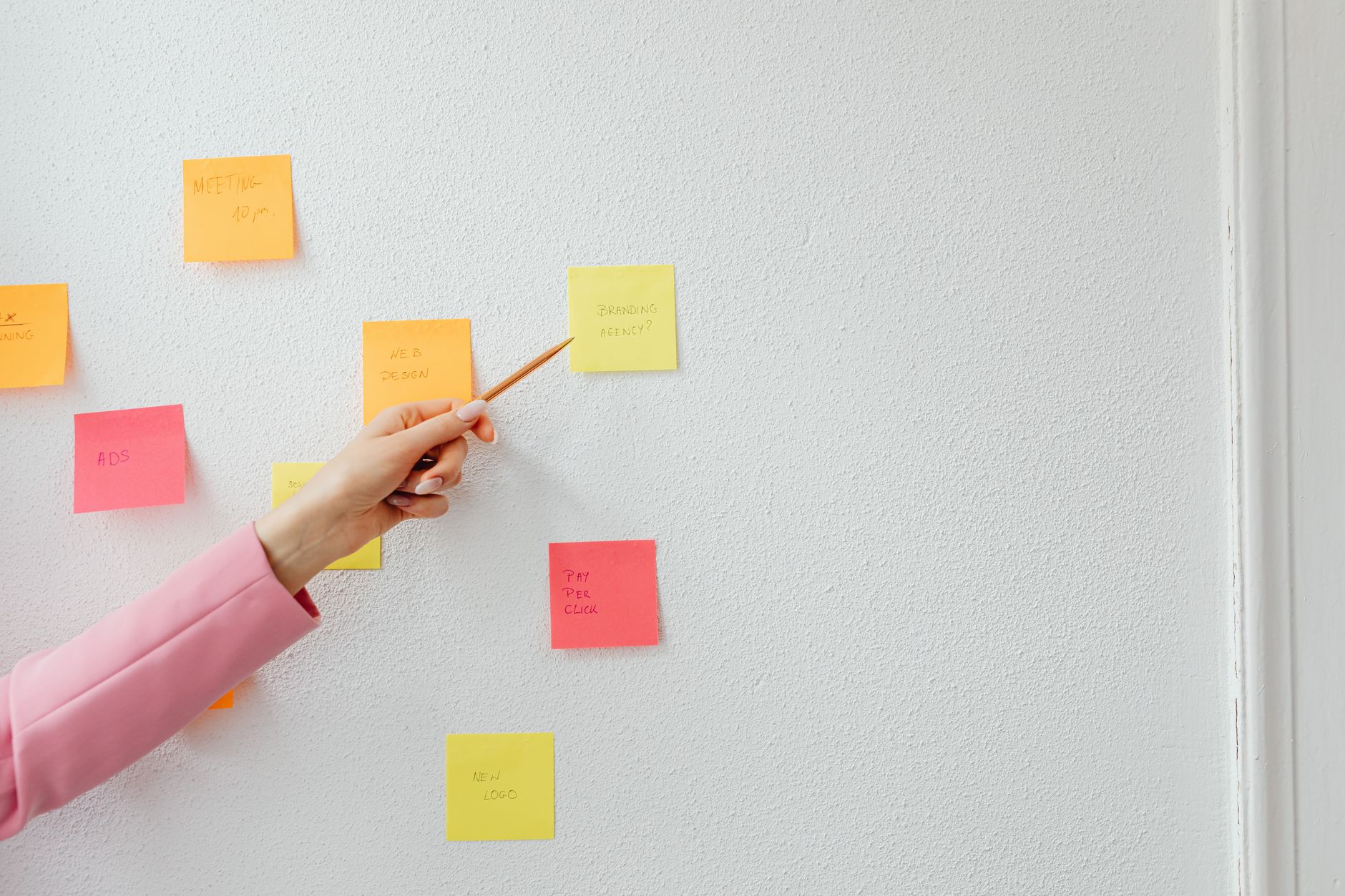 A hand organizes colorful notes during a planning session.