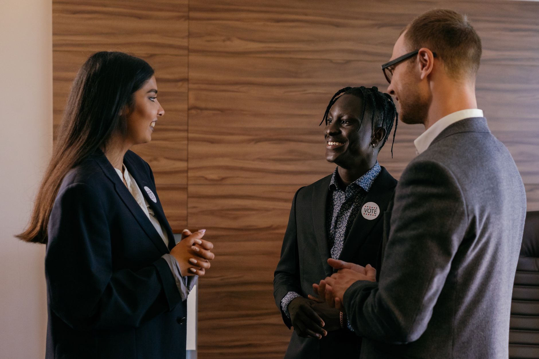 Three professionals talking in a modern conference room