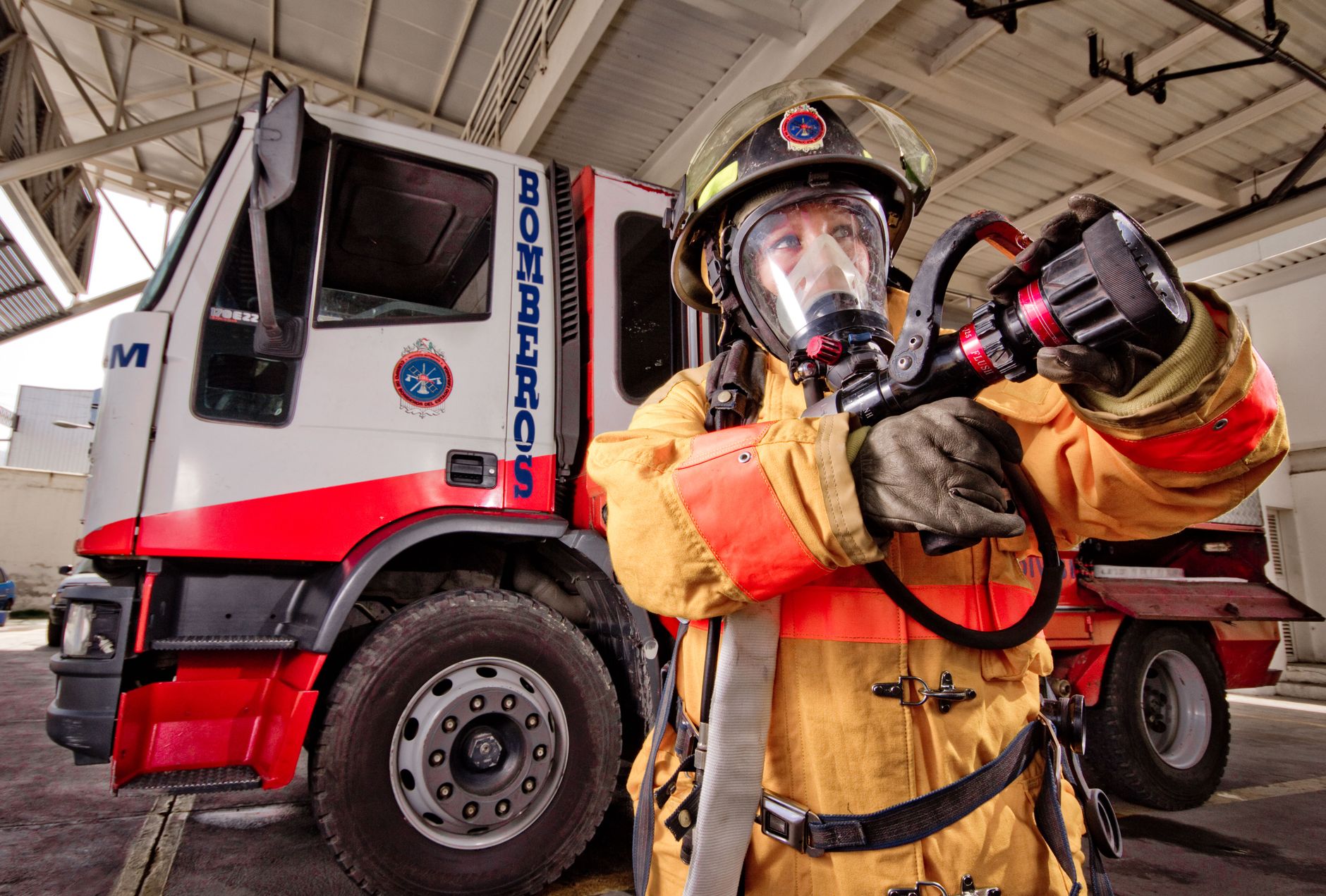 Firefighting turnout gear and helmet laid out ready on a station floor