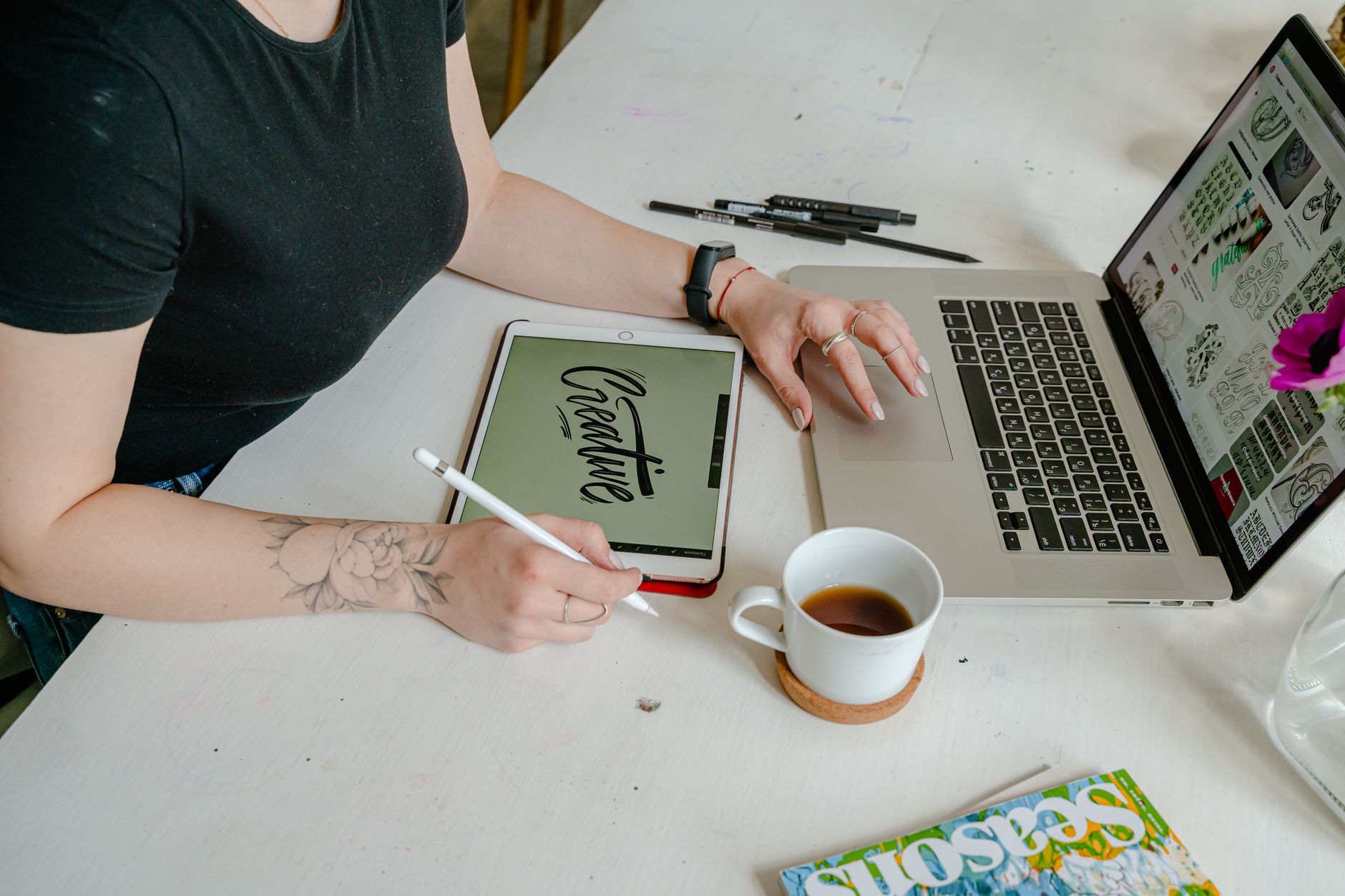 A designer concentrating on a tablet and laptop