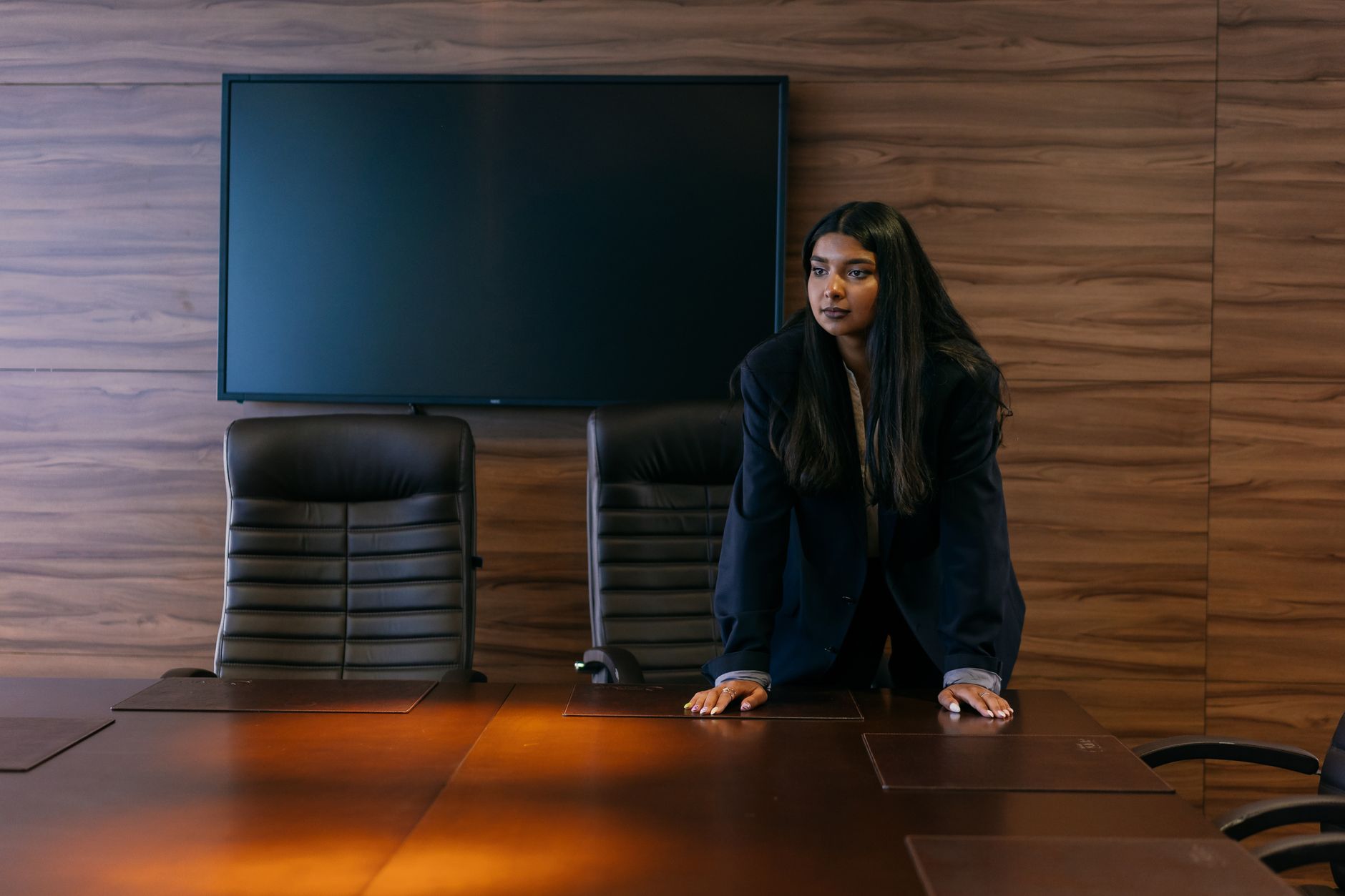 Two people sitting across a table mid-conversation, one speaking with calm, open body language