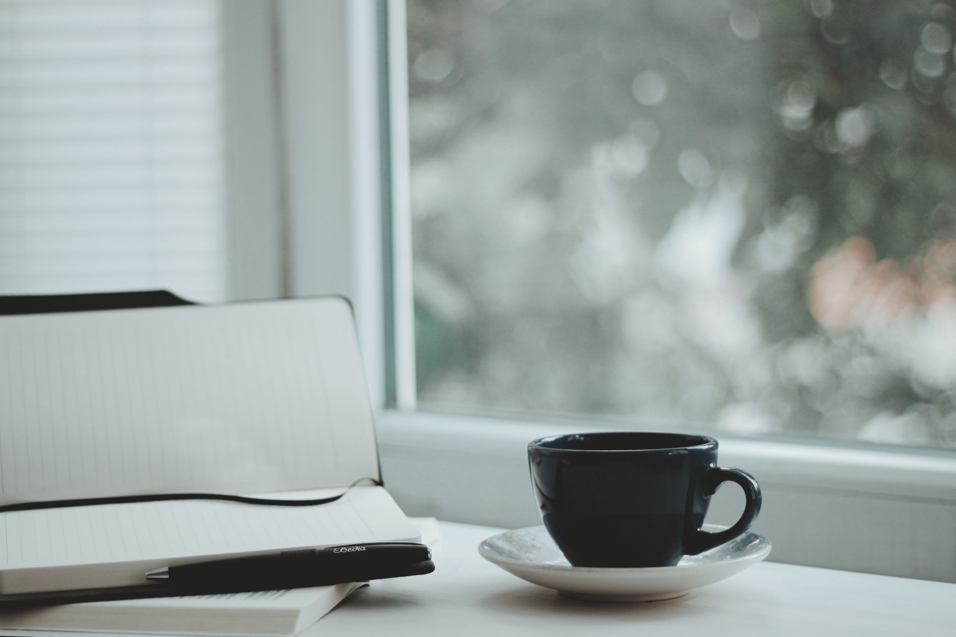 A person recording small completed actions and supportive feedback in a notebook