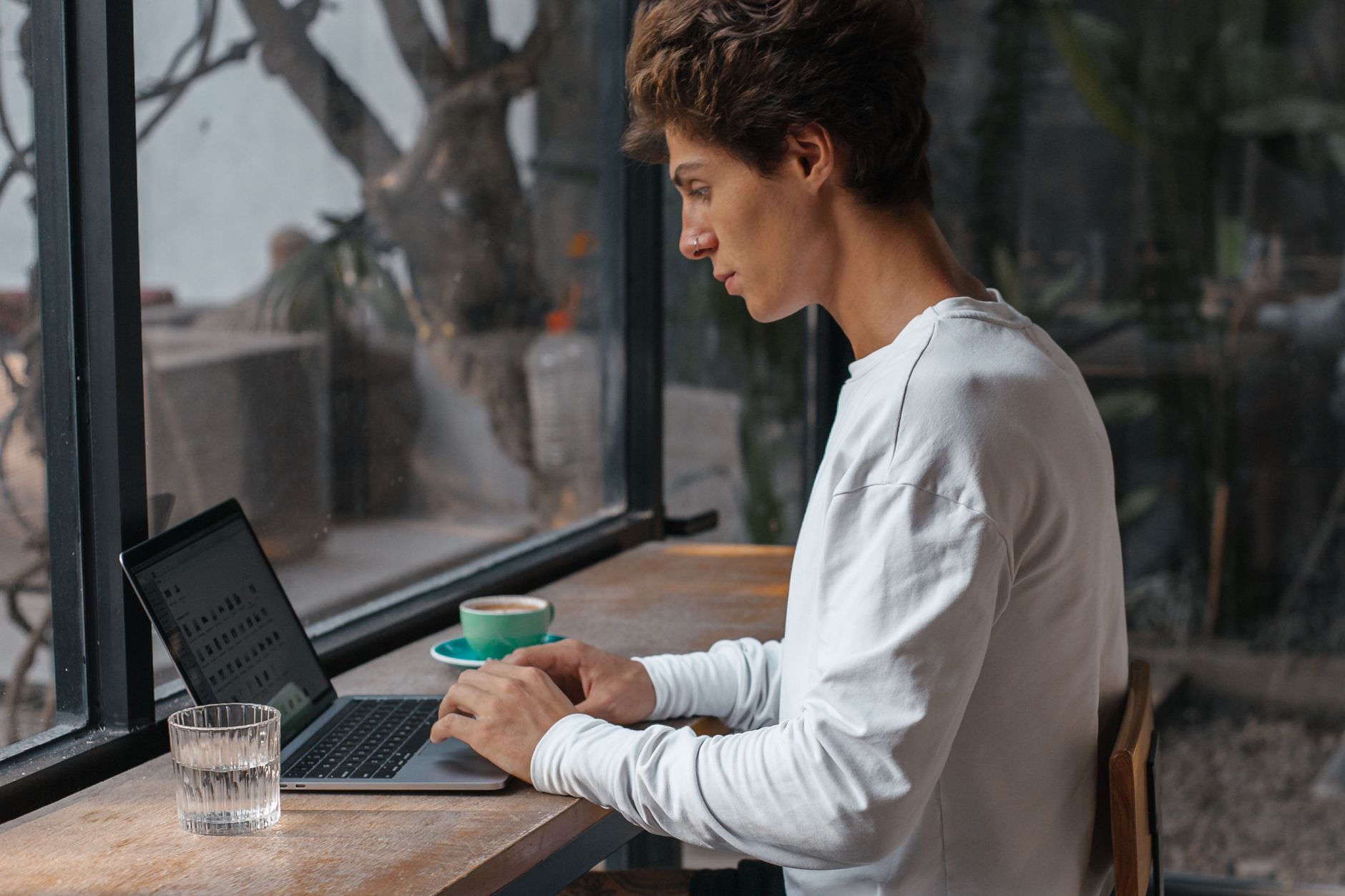 A freelancer working at a laptop on a small desk, taking on paid service work