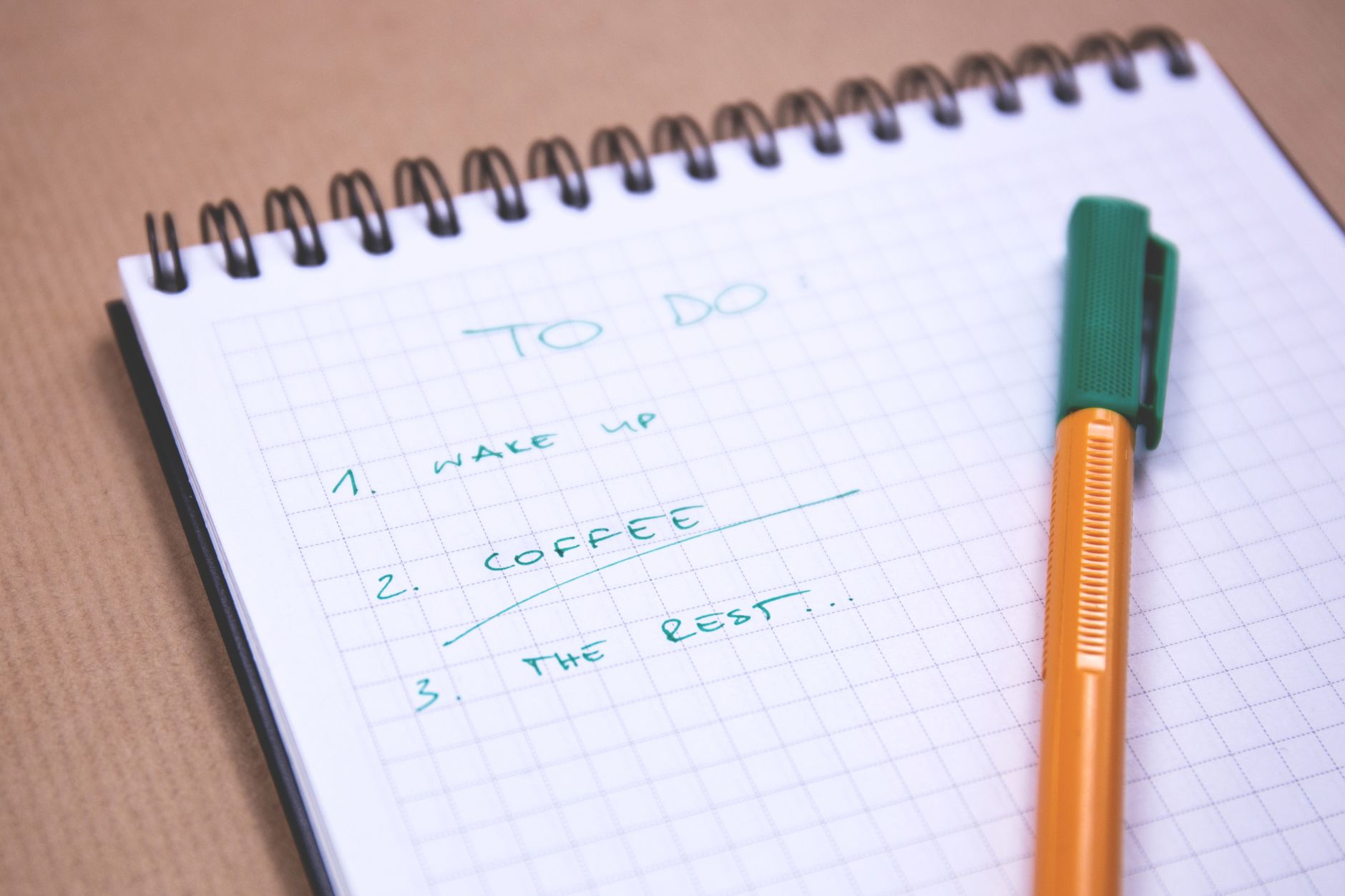 A handwritten to-do list on a notepad with only a few items circled, next to a cup of coffee