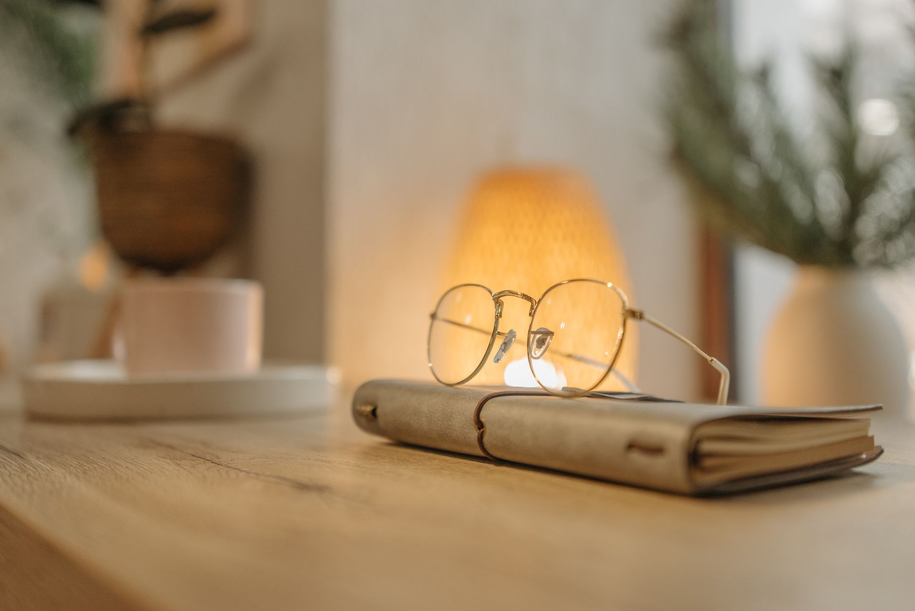 A hand writing a short list in a notebook by lamplight late in the evening