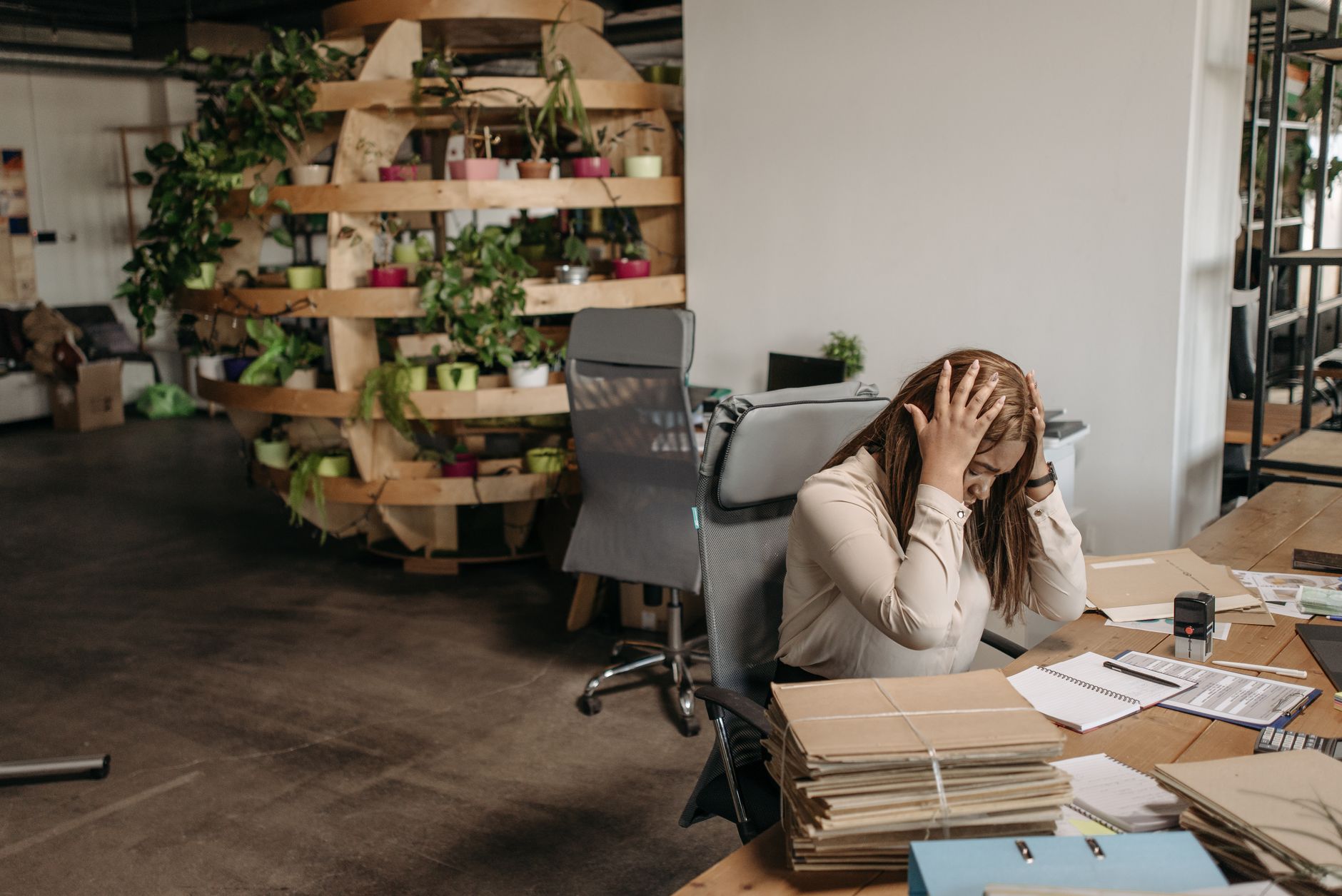 A person calmly selecting a single document from many spread across a table