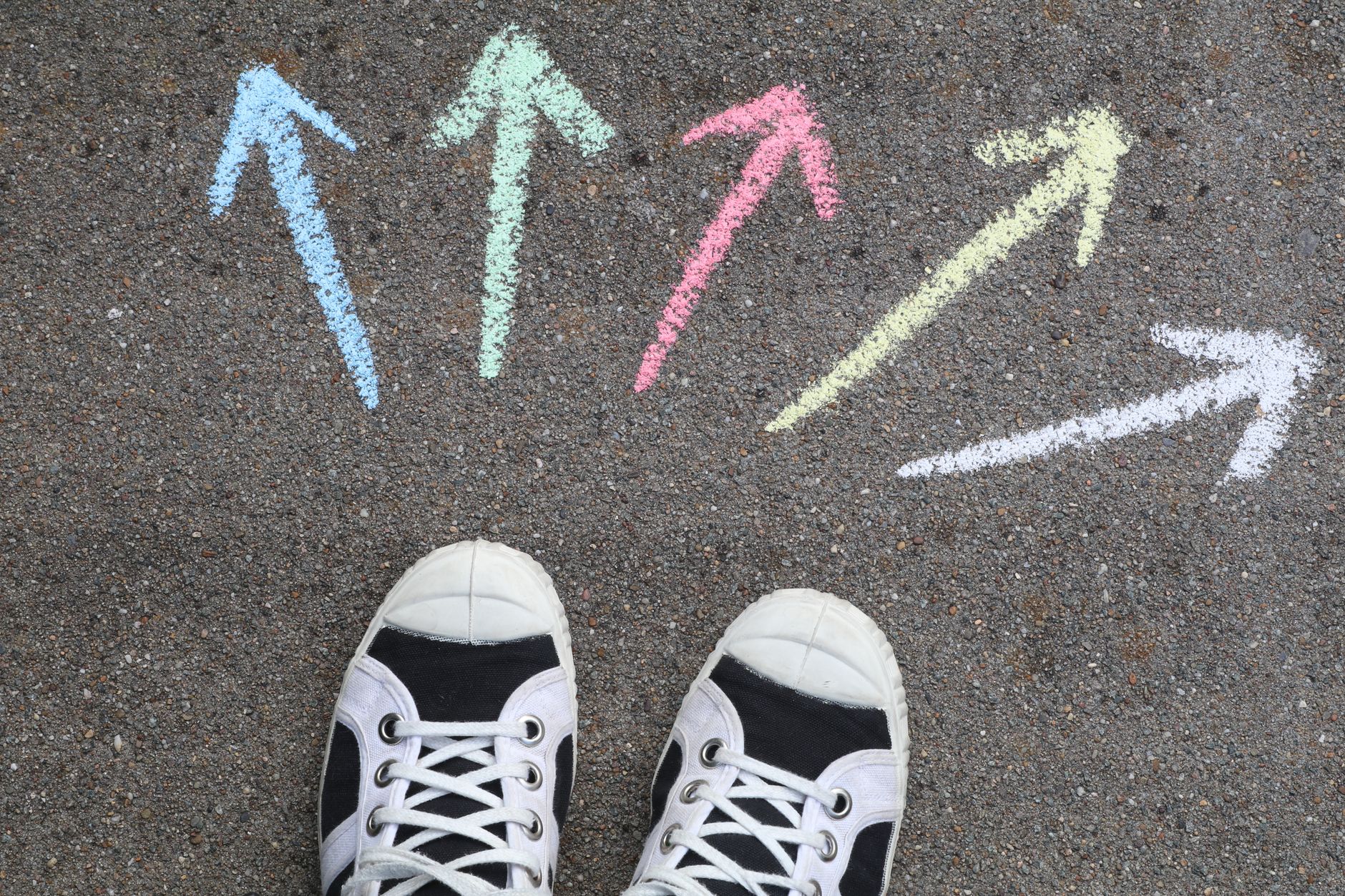 Shoes beside several chalk arrows pointing in different directions