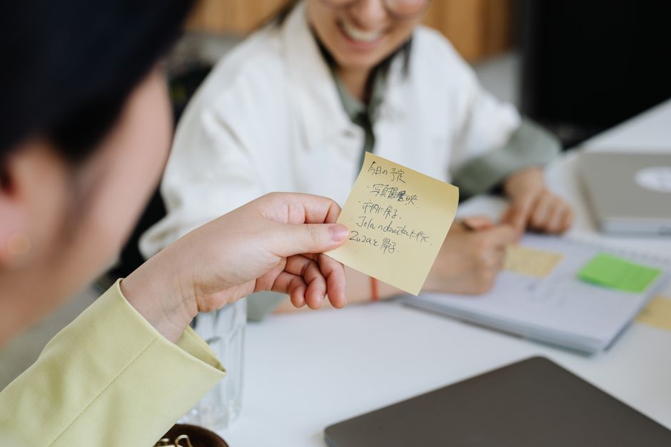 Colleagues reviewing written notes together in an office.