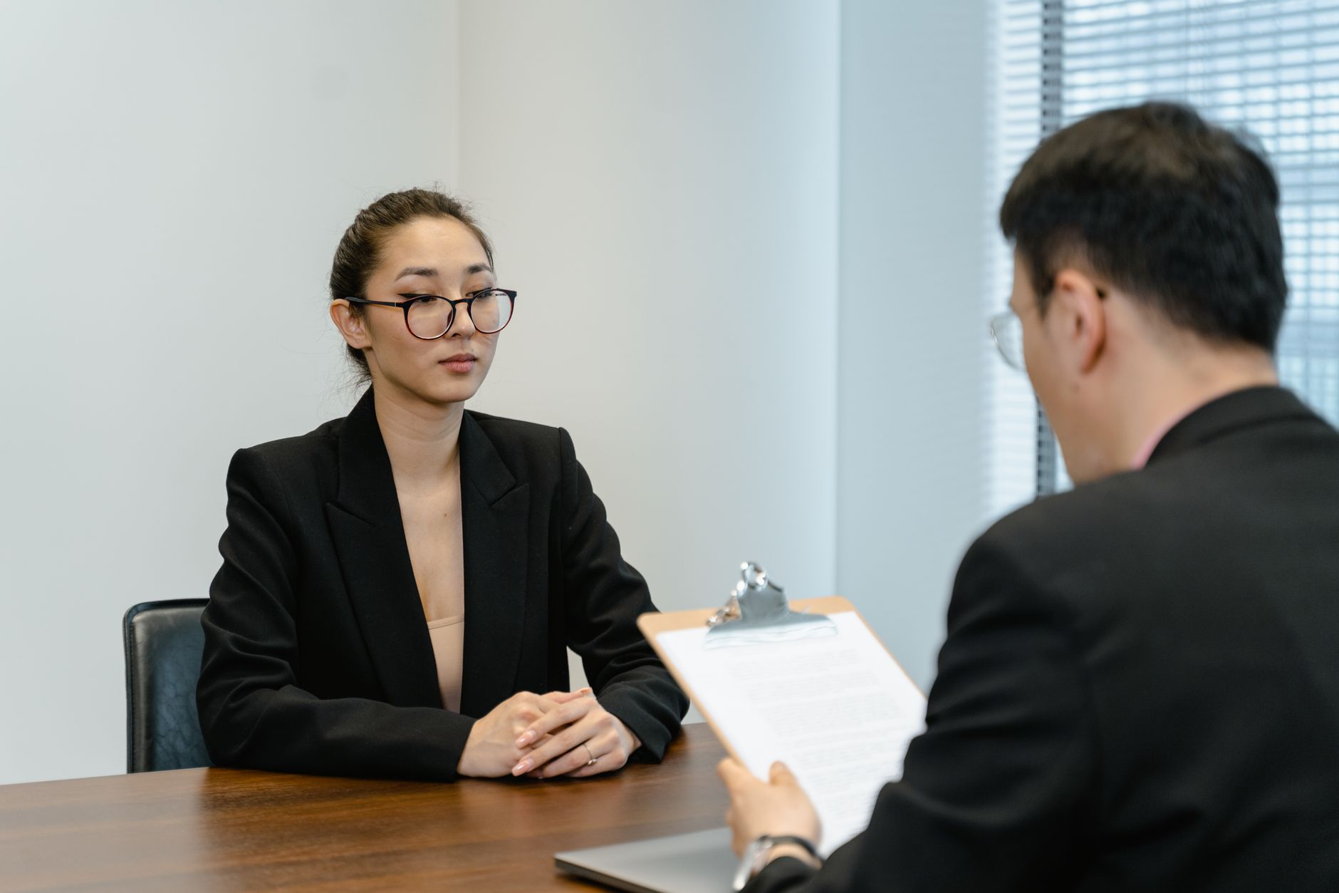 一位求職者坐在會議桌前,微笑著與對面的面試官對話