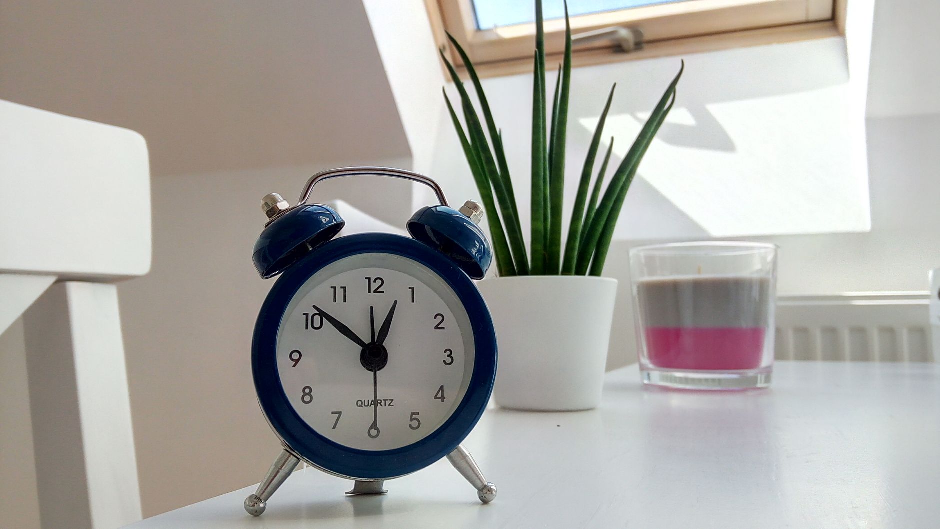 Blue alarm clock on a clean white desk