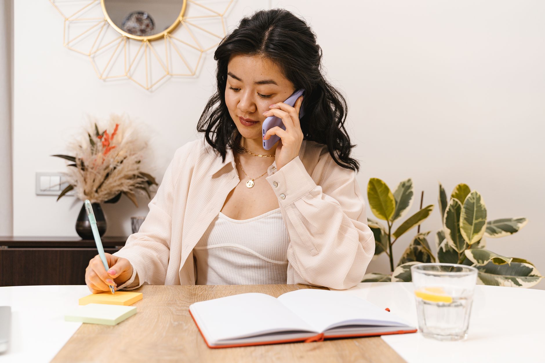 An illustration of a job candidate seated at a desk, phone to their ear, resume and notes spread out in front of them