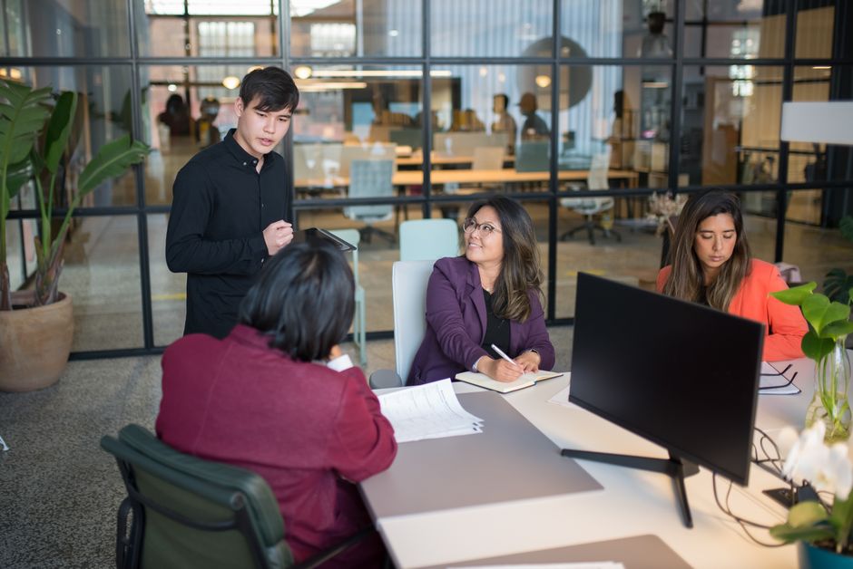 Colleagues discussing a project around an office table.