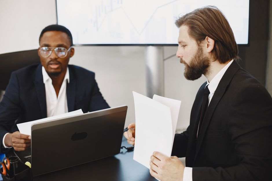 Two colleagues discussing a document in a modern office.