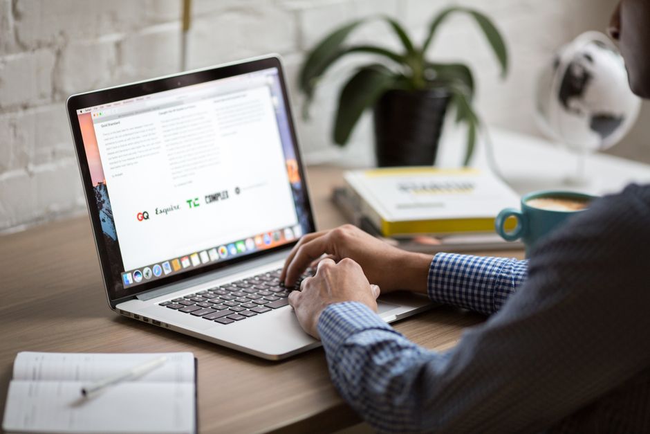 A professional reads and answers email at a desk.