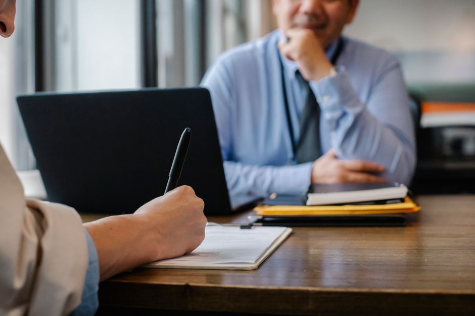 A job seeker reviews a form across from an employer.