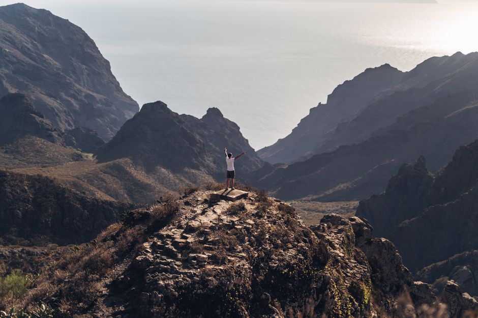 A climber stands on a peak after completing a difficult ascent.