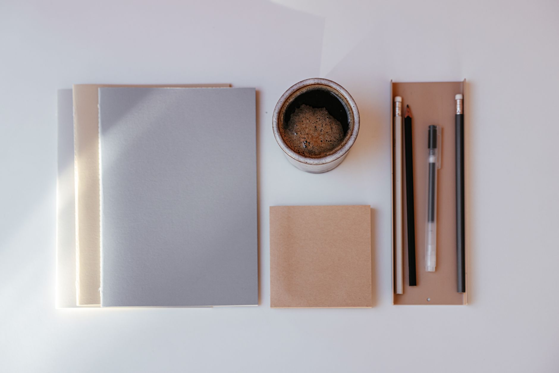 A cup of coffee beside a closed laptop on a quiet table, no second screen in sight