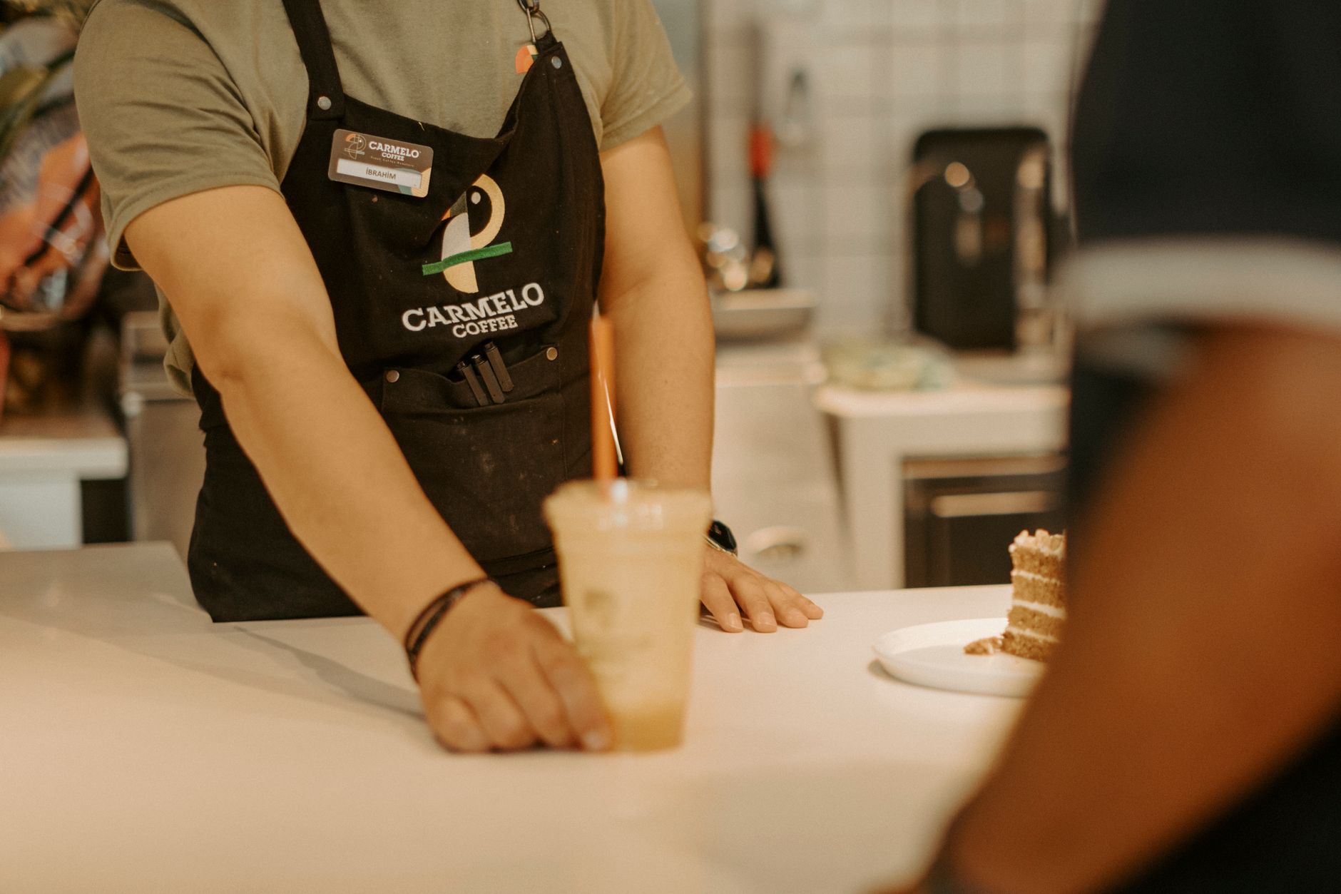 Two Starbucks employees working side by side behind the espresso bar during a busy rush