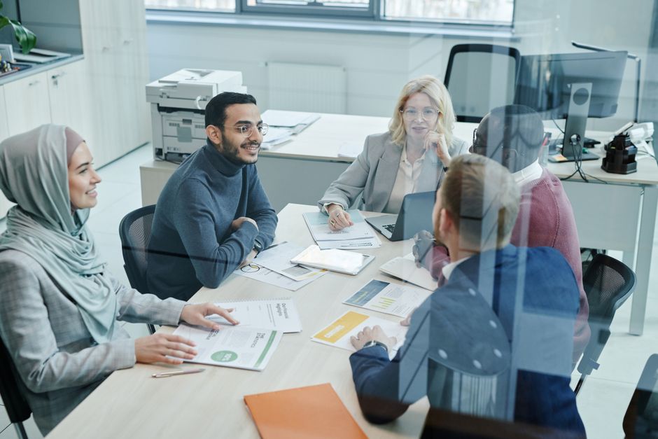 Employees discussing work inside a conference room.