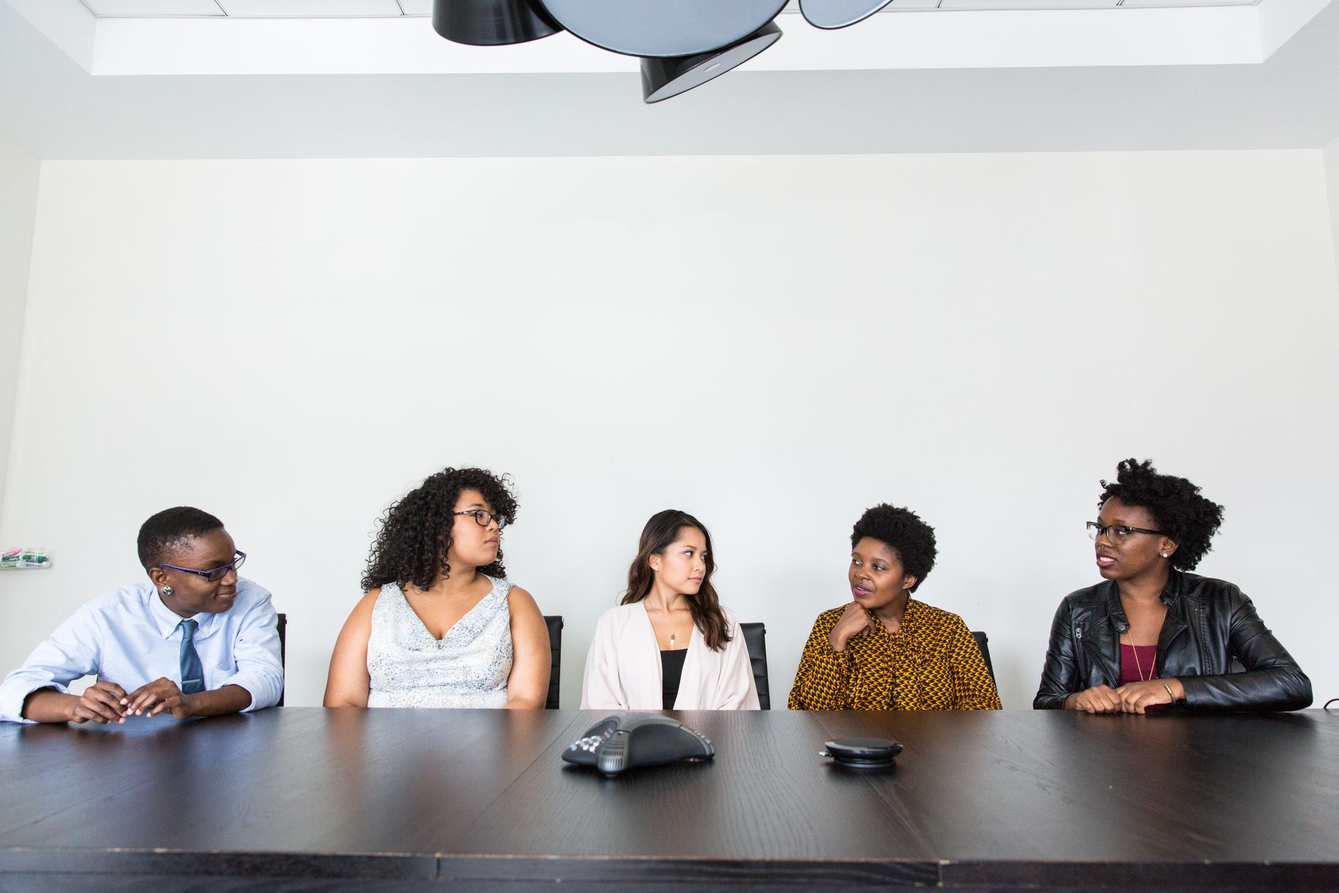 Four job candidates seated in a row, waiting to be called into a group interview together
