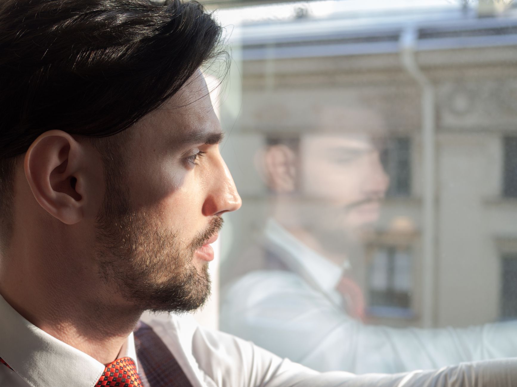 A person sitting alone at a window seat, notebook open, thinking about a career decision