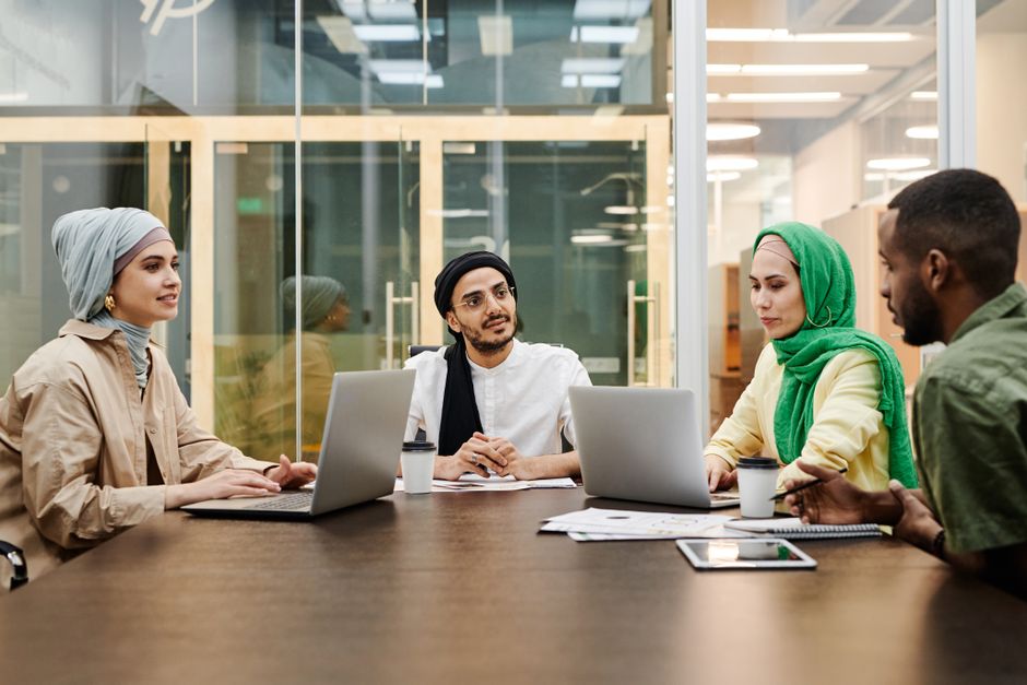 A group discussing documents and devices in a meeting.
